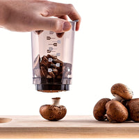 Hand drückt Pilzschneider, braune Champignons, Küchengerät, transparent, Holzbrett.