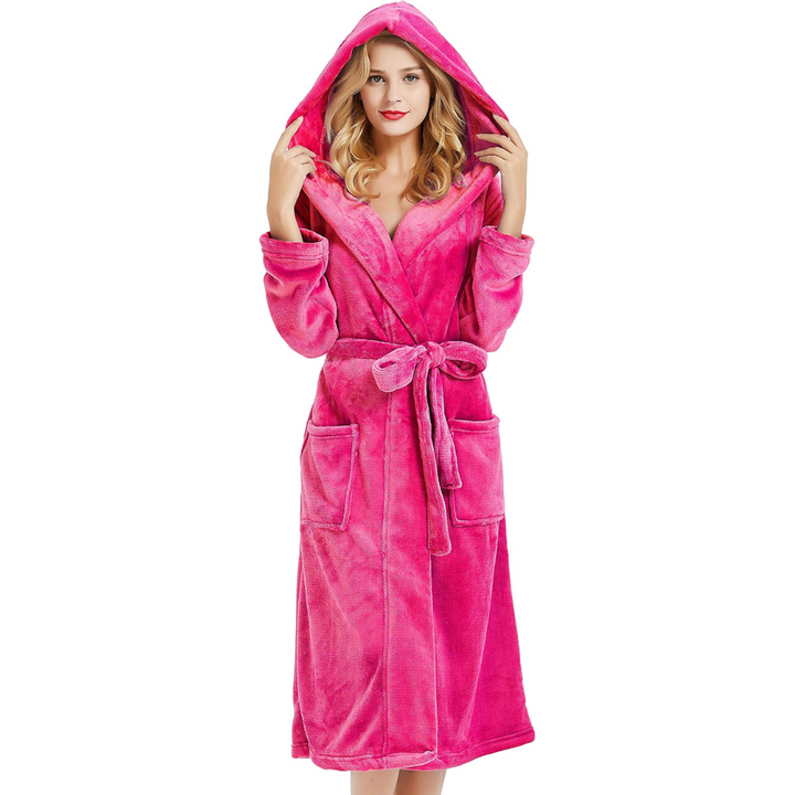 Frau im pinken Fleece-Bademantel mit Kapuze, Taschen und Gürtel, gemütliche Damenmode.