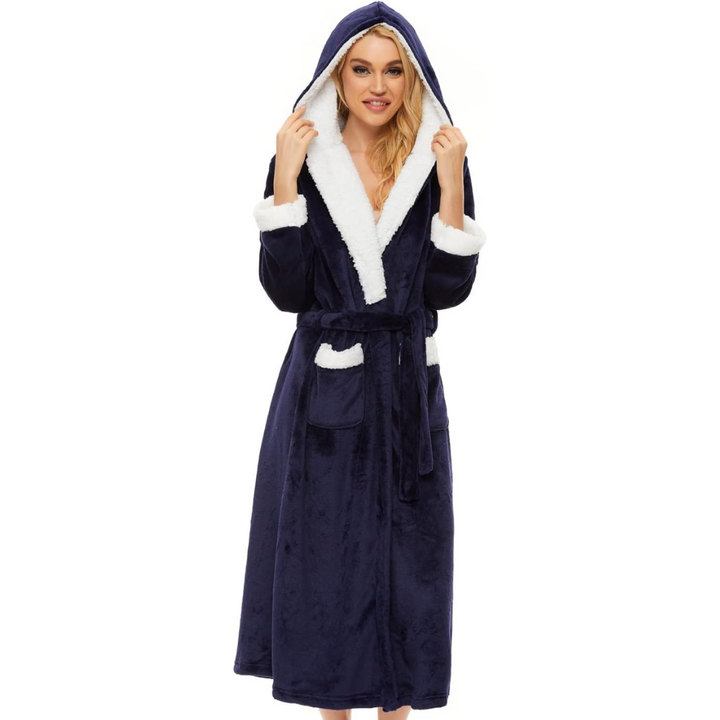 Frau im blauen Fleece-Bademantel mit Kapuze und weißen Details, gemütliche Nachtwäsche.