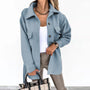 Frau in blauer Wolljacke, weiße Bluse, beige Hose, kariertes Handtasche, modisch, elegant.