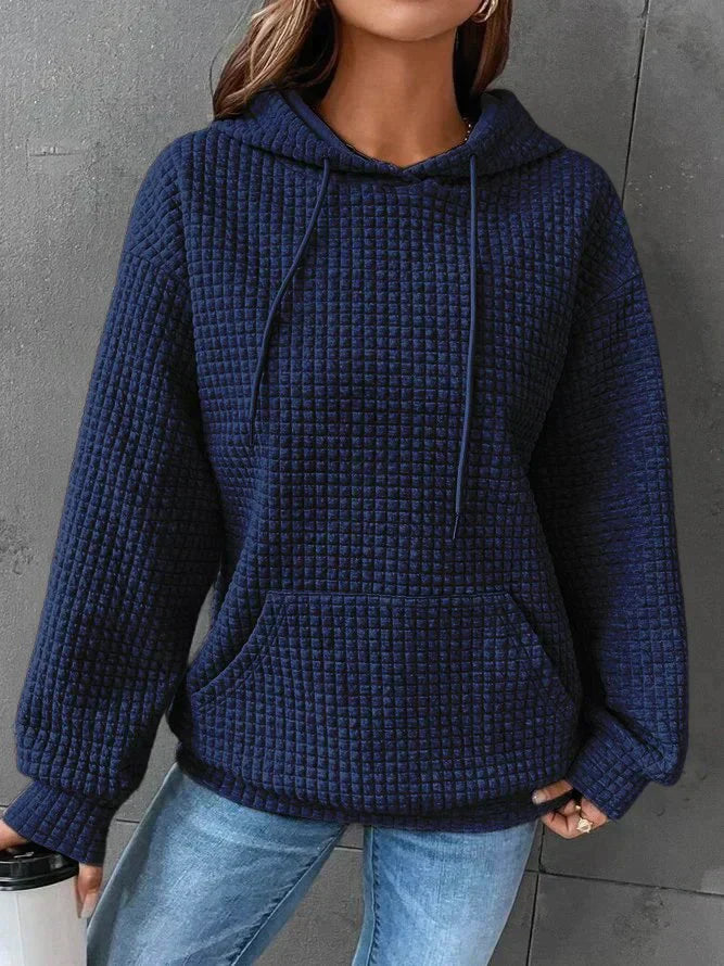 Frau in blauem Kapuzenpullover aus Strickstoff, lässig, modisch, Herbstmode, Jeans.