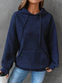 Frau in blauem Kapuzenpullover aus Strickstoff, lässig, modisch, Herbstmode, Jeans.