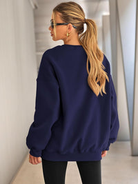 Frau in dunkelblauem Oversize-Pullover, blonde Haare, Sonnenbrille, moderne Mode.