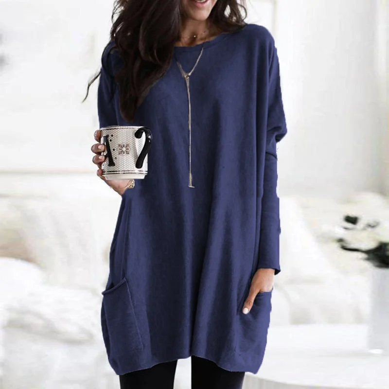 Frau in blauem Oversize-Pullover mit Kaffeetasse, lässige Mode, gemütlicher Look.