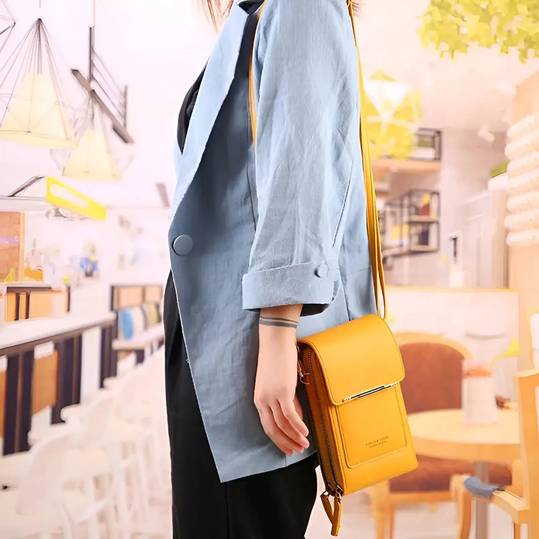 Frau mit hellblauem Blazer und gelber Ledertasche in modernem Café.