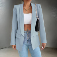 Frau in hellblauem Blazer, weißem Top, Jeans; modischer Look, eleganter Stil, Damenmode.
