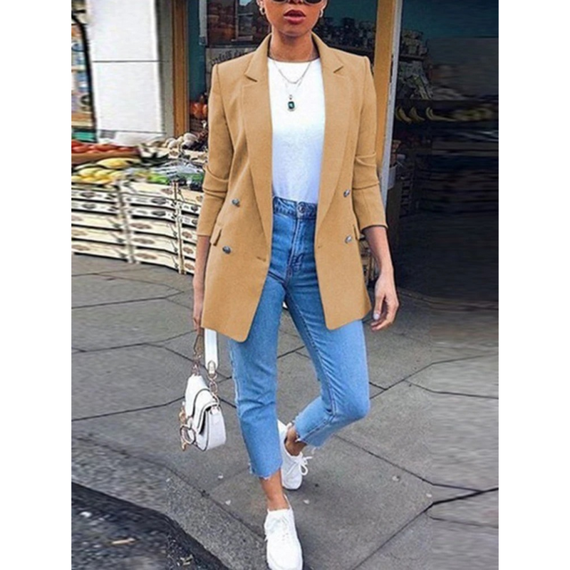 Frau in hellbraunem Blazer, weißem Shirt, blauer Jeans, weiße Sneaker, modisch, urban.