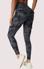 Frau in grauer Camouflage-Leggings mit Taschen, sportlich, bequem, modisch, Fitnessbekleidung.