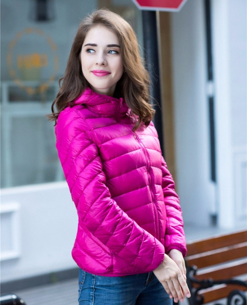 Frau in pinker Daunenjacke, lächelnd, draußen, modisch, Herbstmode, Damenbekleidung.