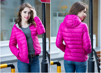 Frau in pinker Daunenjacke, lächelnd, draußen, modisch, Winterbekleidung, urbaner Hintergrund.