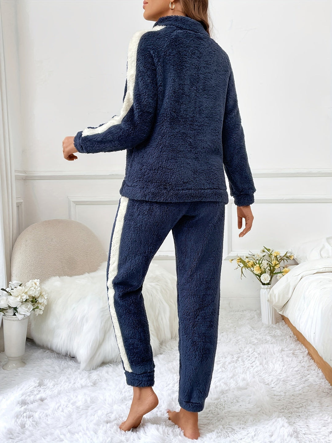 Frau in dunkelblauem Fleece-Trainingsanzug mit weißen Streifen, gemütlich, modern, modisch.