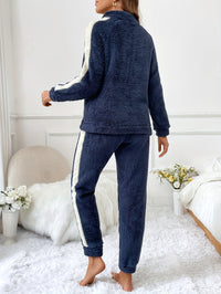 Frau in dunkelblauem Fleece-Trainingsanzug mit weißen Streifen, gemütlich, modern, modisch.