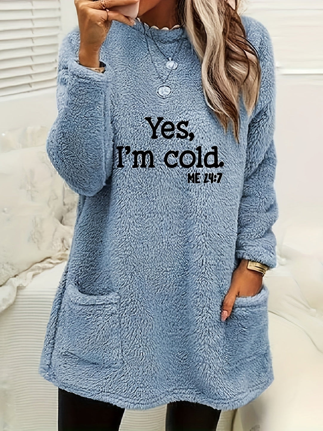 Frau in blauem Fleece-Pullover mit Aufschrift "Yes, I'm cold", gemütliche Wintermode.