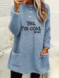 Frau in blauem Fleece-Pullover mit Aufschrift "Yes, I'm cold", gemütliche Wintermode.