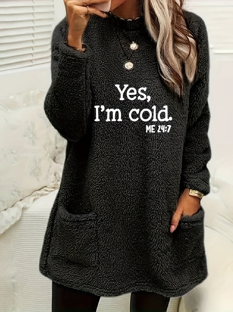 Frau in schwarzem Fleece-Pullover mit Aufschrift "Yes, I'm cold", lässige Wintermode.