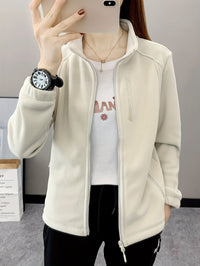 Frau in weißer Fleecejacke, Smartphone, Armbanduhr, lässiger Stil, Mode, Damenbekleidung.