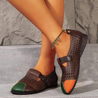 Braune Damen-Lederslipper mit grün-orange Spitze, perforiertem Design und Schnalle.