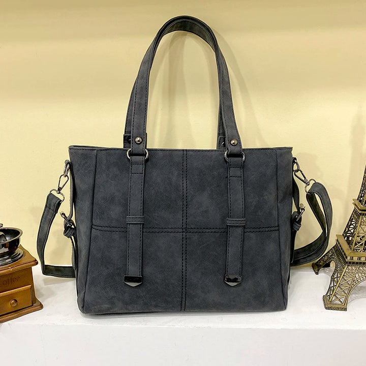 Graue Damenhandtasche aus Leder mit Schulterriemen, elegant und geräumig, modisches Accessoire.