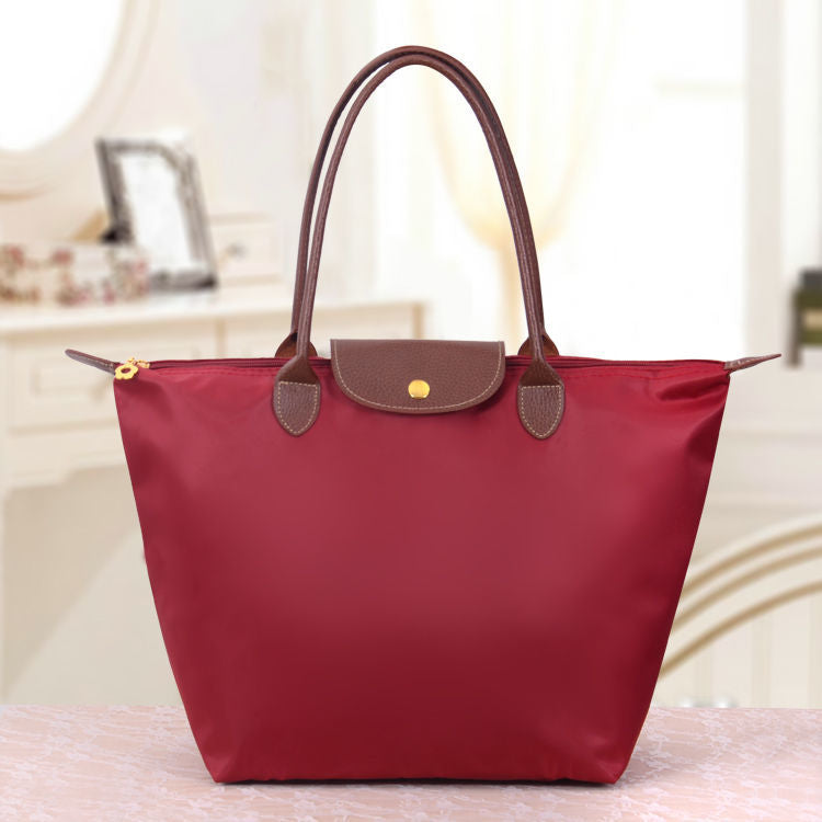 Dunkelrote Handtasche aus Leder und Nylon, elegant, modisch, für Damen.