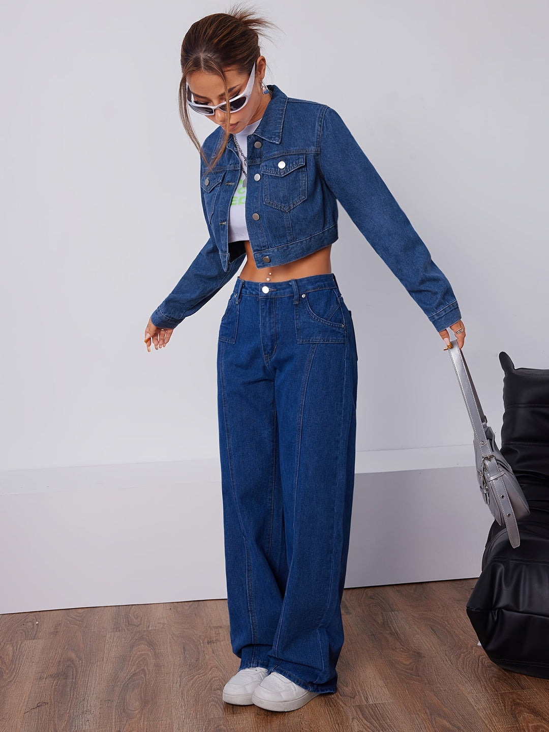 Frau in blauer Jeansjacke und Jeanshose, weiße Sneakers, modisch, lässiger Stil, Holzfußboden.