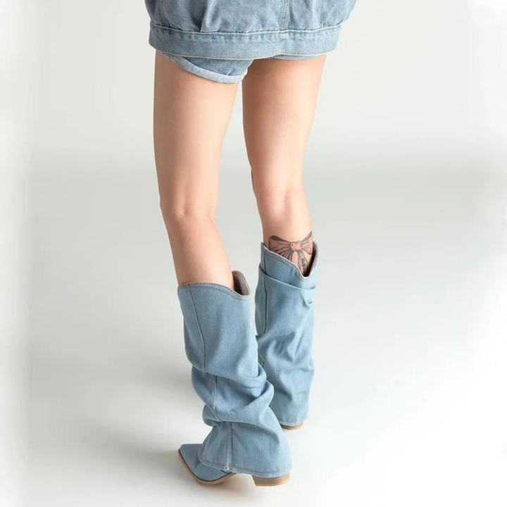 Frau in blauen Jeansstiefeln und Jeansshorts, Rückansicht, modisch, lässiger Stil.