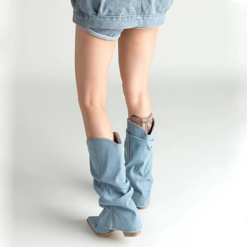 Frau in blauen Jeansstiefeln und Jeansshorts, Rückansicht, modisch, lässiger Stil.