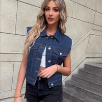 Frau in blauer Jeansweste und schwarzer Shorts auf Treppe, modische Freizeitkleidung.