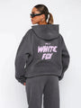 Frau in grauem Hoodie mit "White Fox" Aufdruck, Sonnenbrille, lässiger Stil.