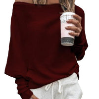Frau in rotem Off-Shoulder-Pullover mit Kaffee, lässige Mode, Herbstoutfit.