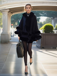 Eleganter schwarzer Damen-Poncho aus Samt, ideal für Herbstmode, getragen von Frau auf Straße.