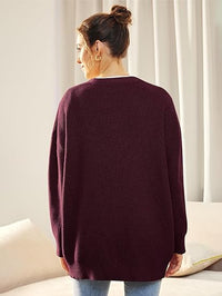 Frau in burgunderrotem Strickpullover, Rückansicht, lässige Mode, gemütliches Wohnzimmer.