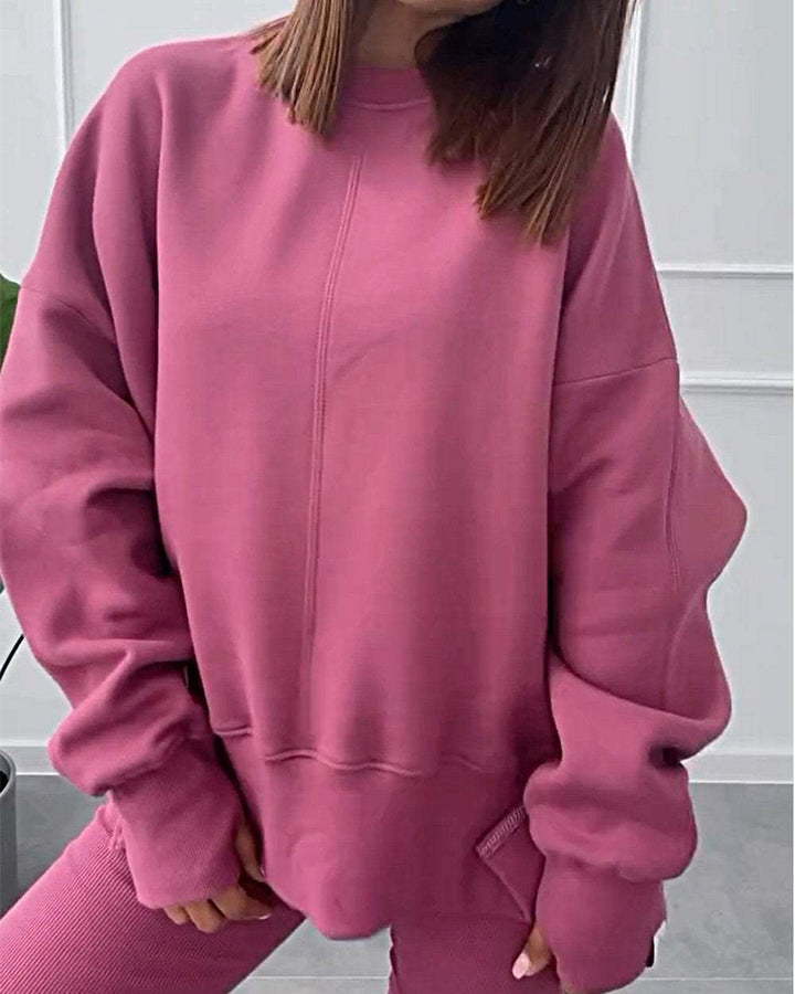 Frau in rosa Oversize-Sweatshirt und Leggings, gemütliche Damenmode, Freizeitkleidung.