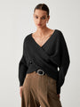 Frau in schwarzem Strickpullover und brauner Hose, modisch, elegant, Herbstmode.
