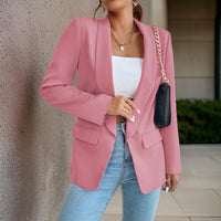 Frau in rosa Blazer, weißem Top, blauer Jeans, schwarze Tasche, modisch, elegant, urbaner Stil.