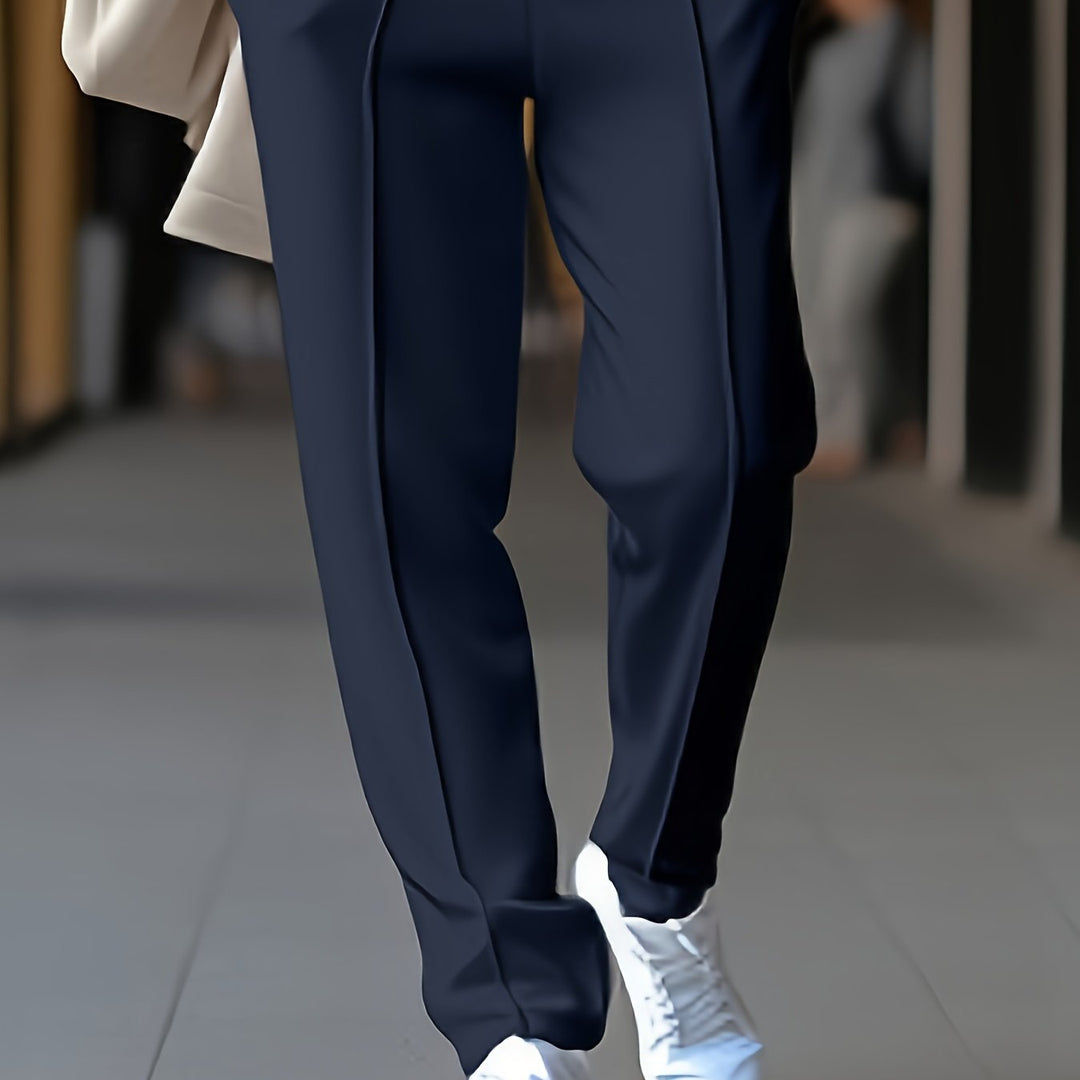 Dunkelblaue Damenhose, elegant, aus Stoff, kombiniert mit weißen Sneakern, modisch, urban.