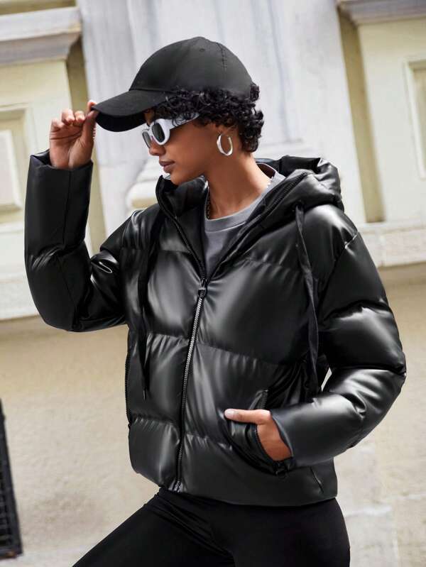 Frau in schwarzer Steppjacke und Baseballkappe, modisch, urbaner Stil, Herbstmode.