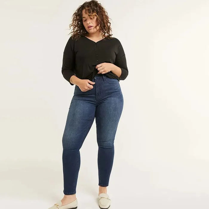 Frau in schwarzem Langarmshirt und blauer Jeans, Plus-Size-Mode, lässiger Stil.