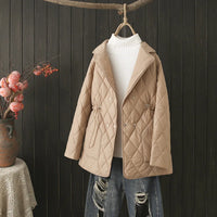 Beige gesteppte Damenjacke, Herbstmode, mit Kordelzug, über weißem Rollkragenpullover.