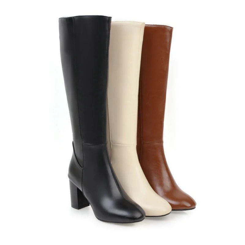 Drei elegante Damenstiefel in Schwarz, Beige und Braun, aus Leder mit Blockabsatz.