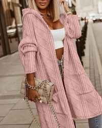 Frau in rosa Strick-Cardigan mit Kapuze, weißem Top, beiger Tasche, Stadtstraße.