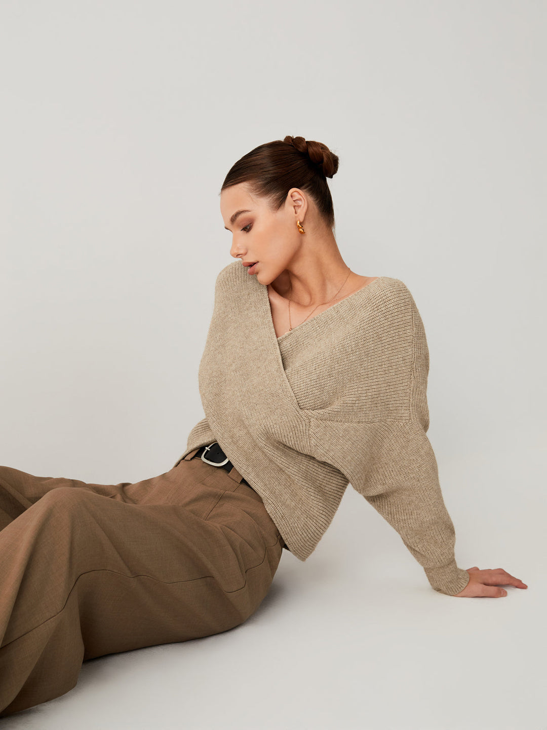 Frau in beigem Strickpullover und brauner Hose, eleganter Look, Modefotografie.
