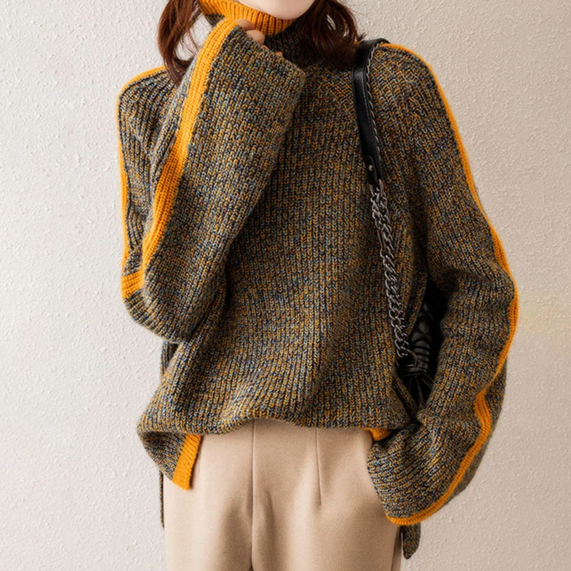 Frau in grauem Strickpullover mit gelben Streifen, beige Hose, schwarze Tasche.