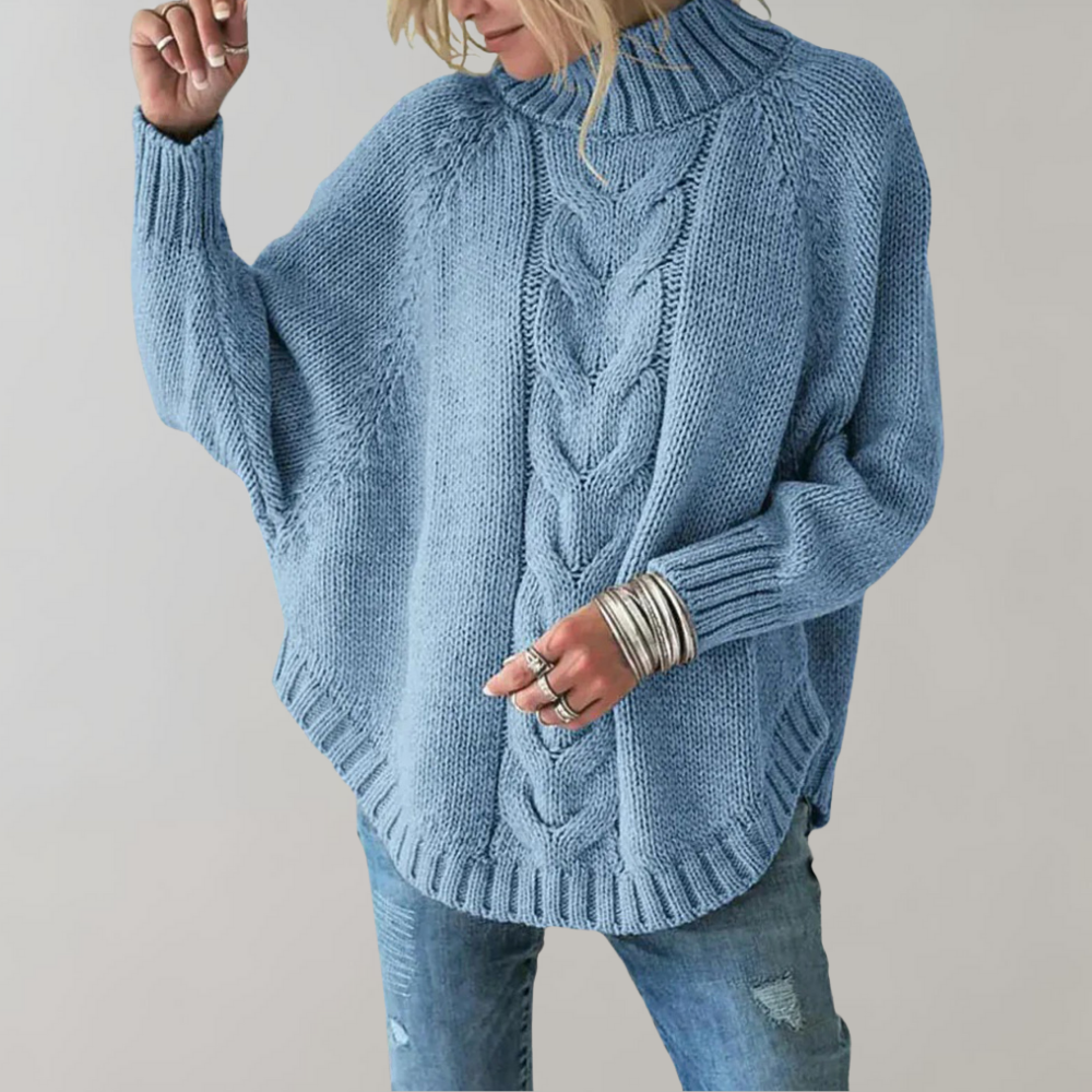 Frau in hellblauem Strickpullover mit Zopfmuster und Jeans, modisch, gemütlich.
