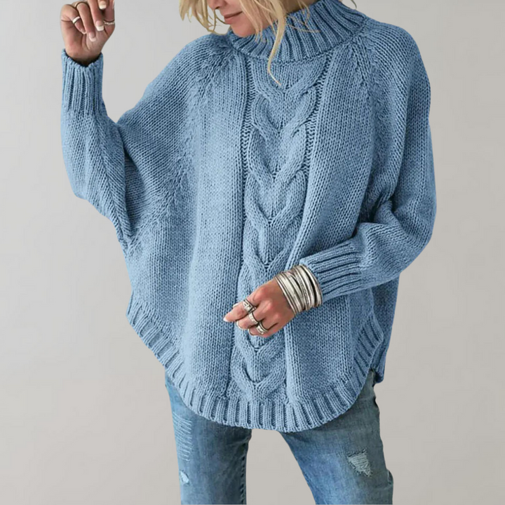 Frau in hellblauem Strickpullover mit Zopfmuster und Jeans, modisch, gemütlich.