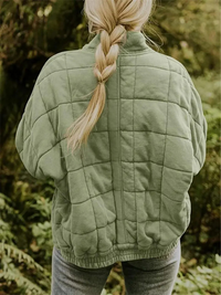 Frau in grüner, gesteppten Übergangsjacke, oversized, im Freien, Herbstmode Damen.