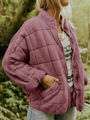 Frau in lila, gesteppter Übergangsjacke, lässig, modisch, Herbstmode, Outdoor, Damenbekleidung.