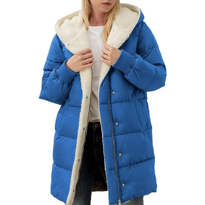 Frau in blauer Daunenjacke mit Kapuze und weißem Innenfutter, Wintermode, warm, stilvoll.