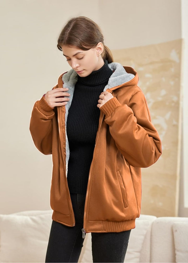 Frau in brauner Winterjacke mit Kapuze, schwarzem Rollkragenpullover, gemütlich, modisch.