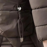 Braune Daunenjacke mit Herzanhänger, gesteppte Struktur, Wintermode, Damenbekleidung.