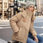 Frau in beige Winterjacke mit Kapuze, warm, winddicht, modisch, Stadtstraße, Wintermode.